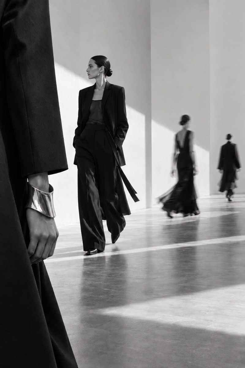 Black-and-white fashion concept with tailored silhouettes moving through a sunlit gallery